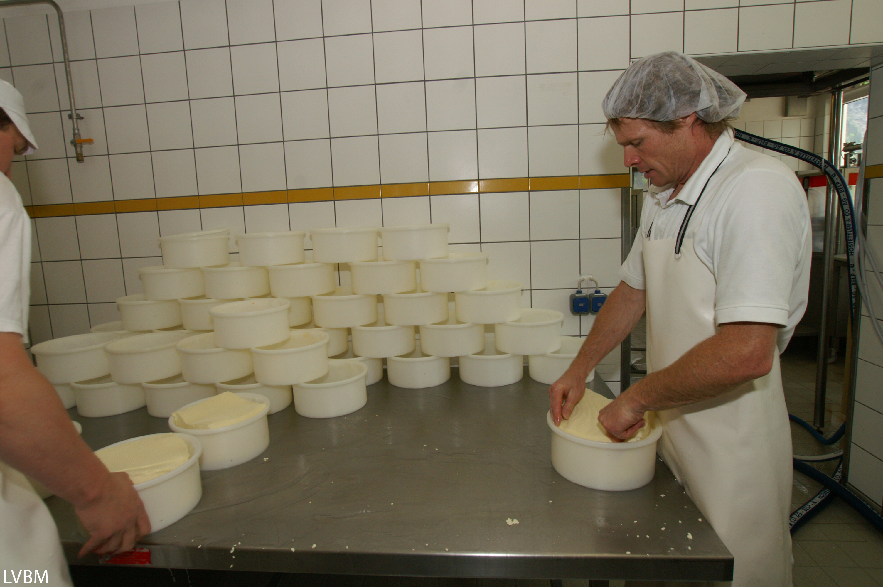 Mann bei der Käseproduktion